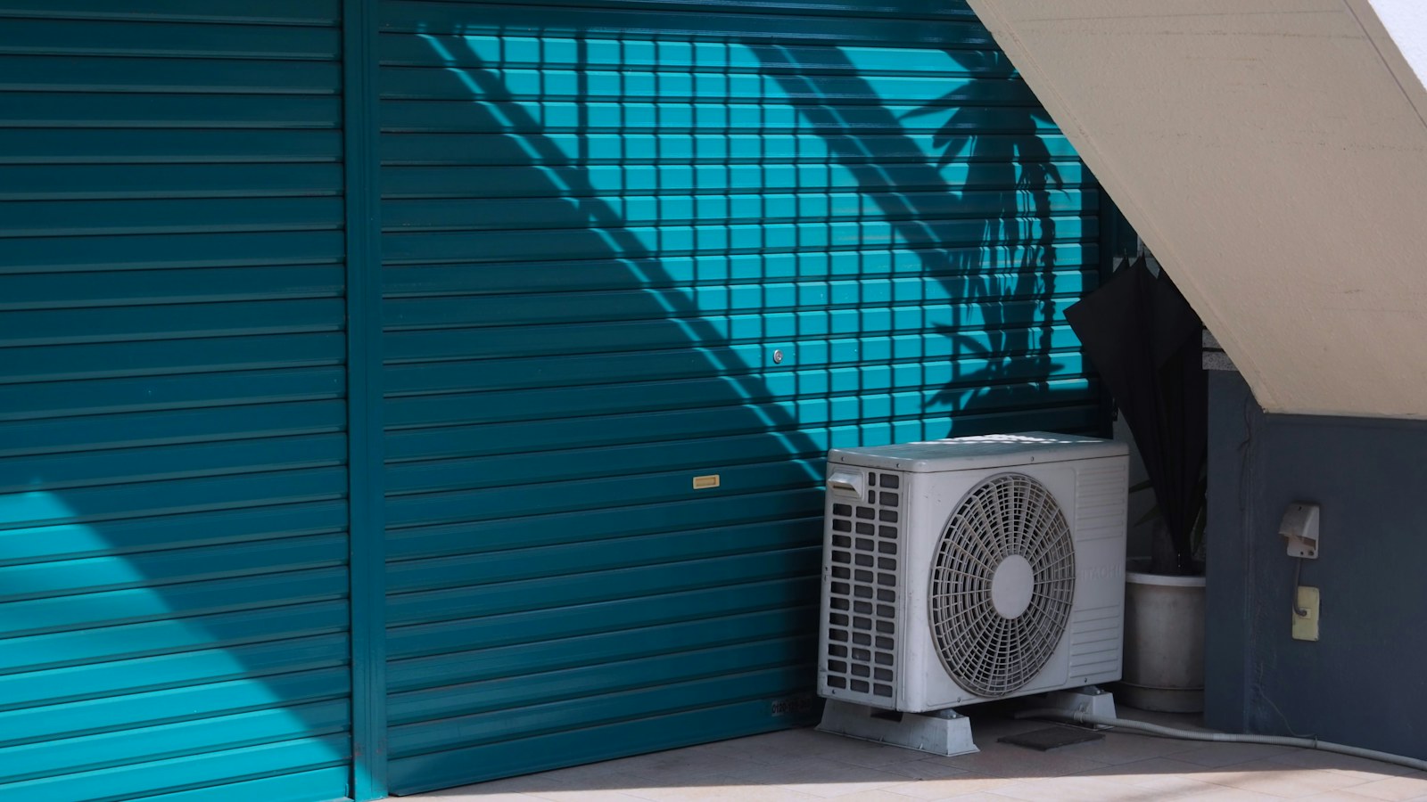 A residential outdoor air-conditioning unit beside a building