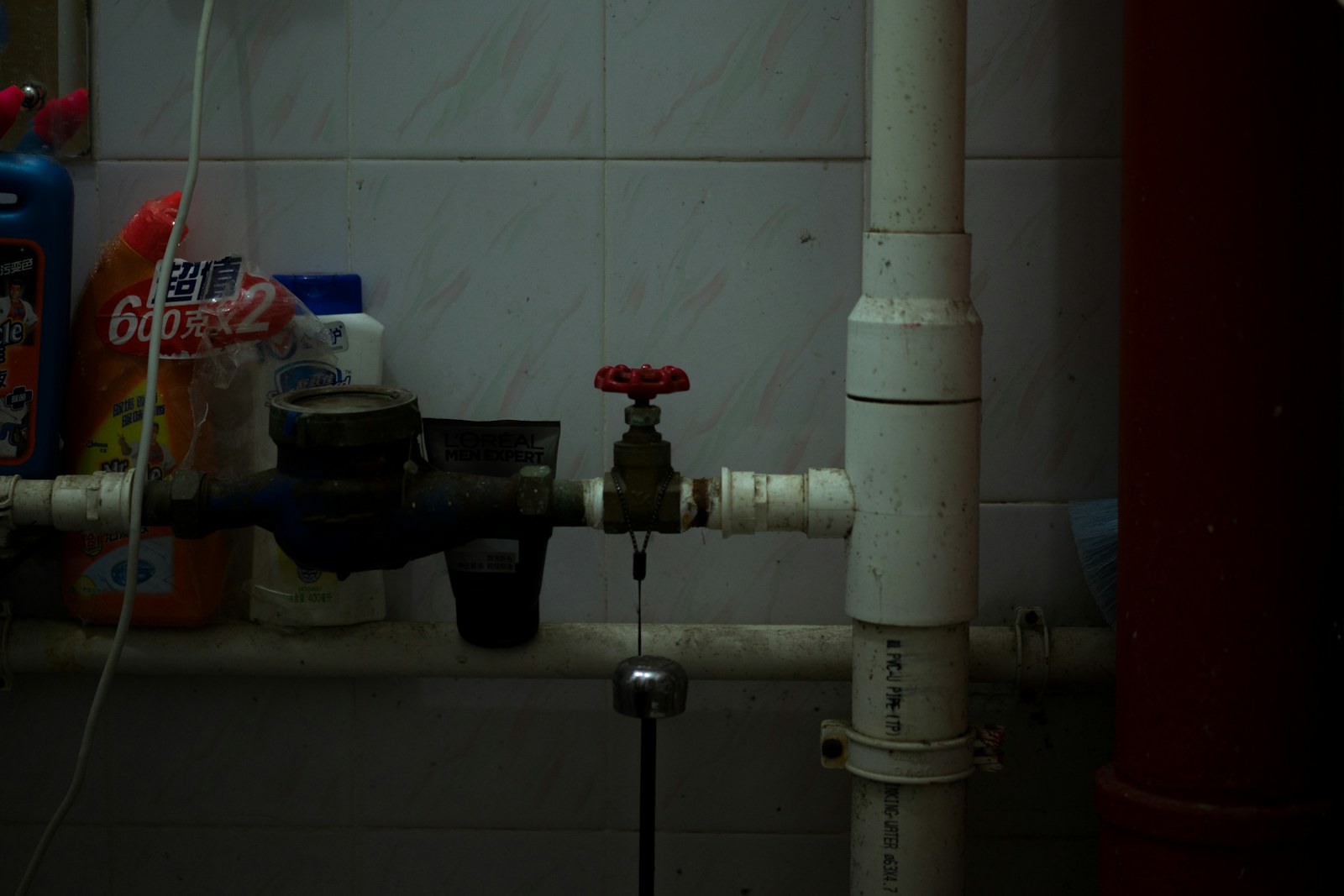 Exposed pipe and valve connected to a bathroom sink