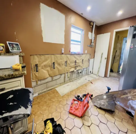 A kitchen interior shown before restoration in a documented under-sink leak case